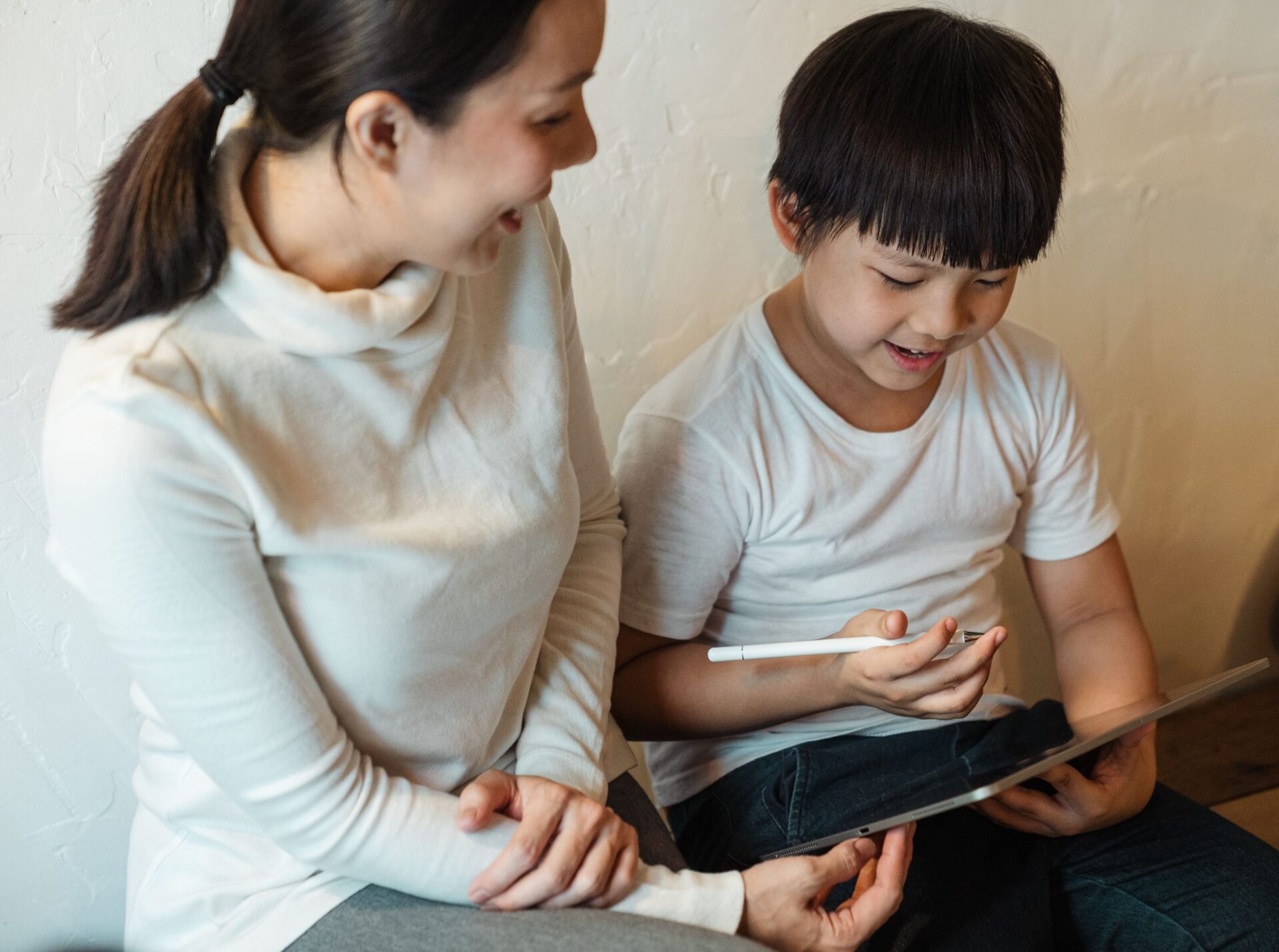 白夜行はなぜ後味が悪いのか|結末の読み方を考察 6 大人と子どもが並んで、タブレットの画面をのぞき込んでいる