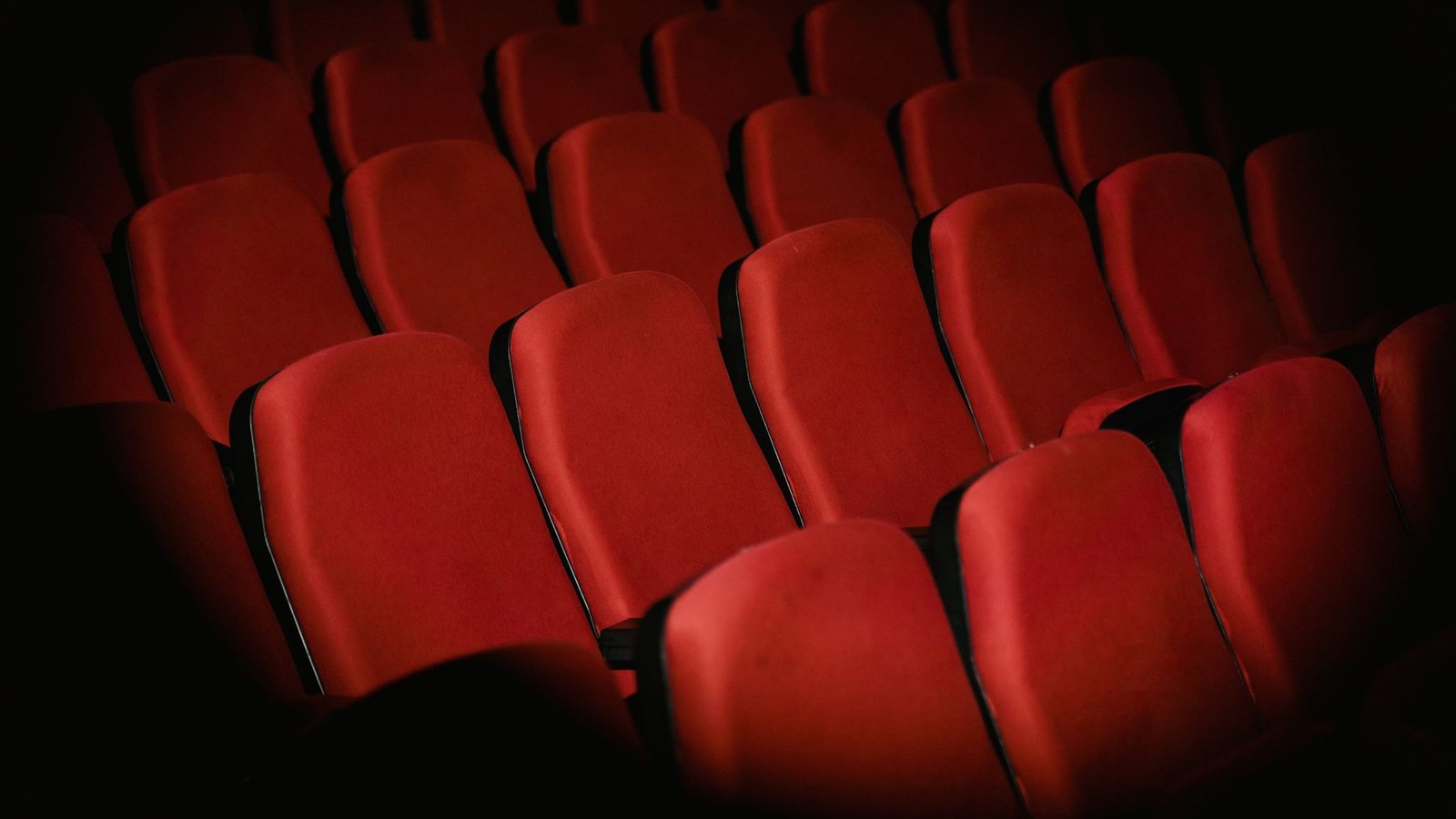 小説の映画化で変わる3つのこと|先に読むか先に観るかの選び方 4 薄暗い映画館に並ぶ空の赤い座席