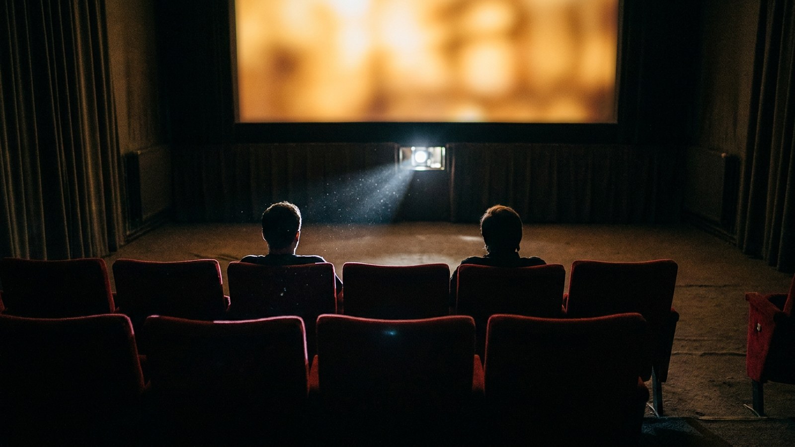 小説の映画化で変わる3つのこと|先に読むか先に観るかの選び方 3 小さな映画館で離れて座る2人とスクリーンの光